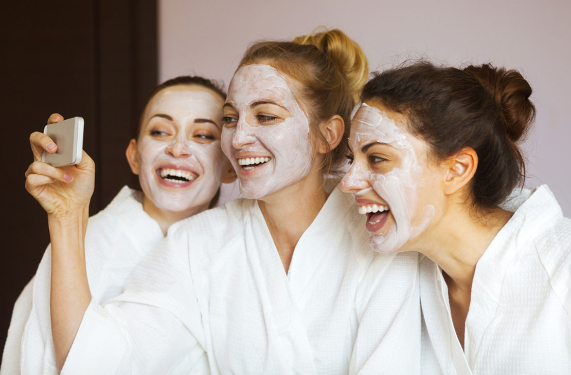 trio of women take photo wearing masks