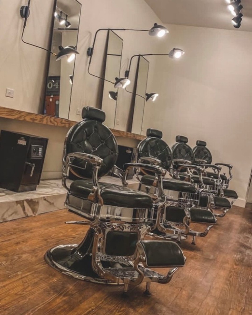 four barber chairs in a small modern barber shop with proper spacing between each chair