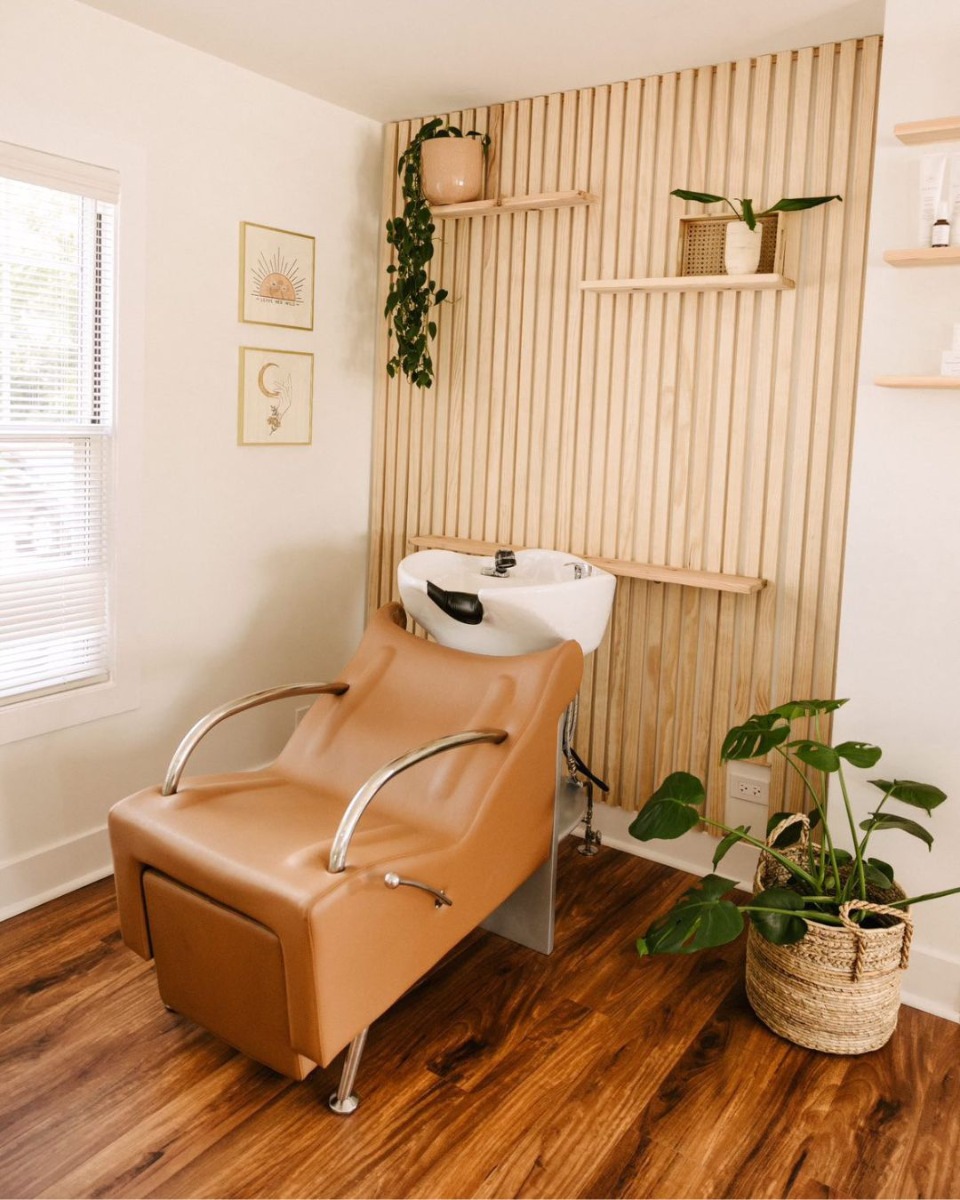low budget salon interior design with neutral colors, plants and a wood paneled accent wall